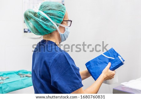 Covid-19. Female nurse puts on protective cloths. Personal protective equipment in the fight against Coronavirus disease . Royalty-Free Stock Photo #1680760831