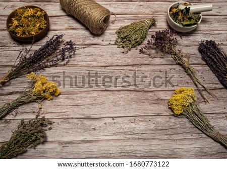 Phytotherapy. Composition of dry herbs for herbal medicine. Collection, a mixture of various dried herbs in bundles and cups on a wooden background. Free space.