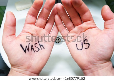 Washing hands.The man looks at his hands which say wash us
