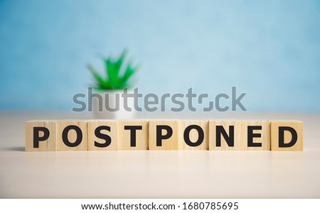 Postponed - words from wooden blocks with letters, postponed concept, top view background Royalty-Free Stock Photo #1680785695