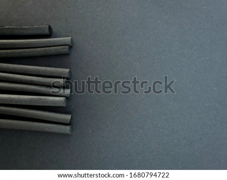 Black background with space to write. On the side a set of charcoals decorate the template. Useful as a background for presentation templates or powerpoint.