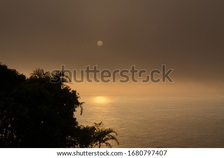 
Evening picture mood with covered sun setting over the sea