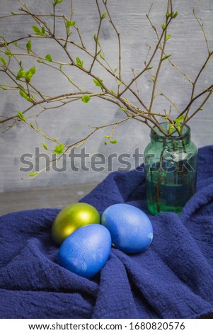 Easter eggs with spring branches on a gray background