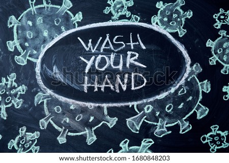 Wash your hand. Outbreak Warning. written white chalk on blackboard in connection with epidemic coronavirus worldwide Covid 19 pandemic Text on black background with free space. drawn virus bacteria