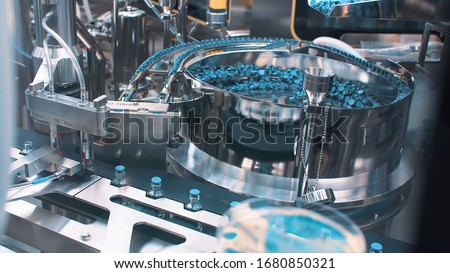 Automatic packaging machine for packaging ampoules with vaccine, injection and medical drugs. coronavirus. Royalty-Free Stock Photo #1680850321
