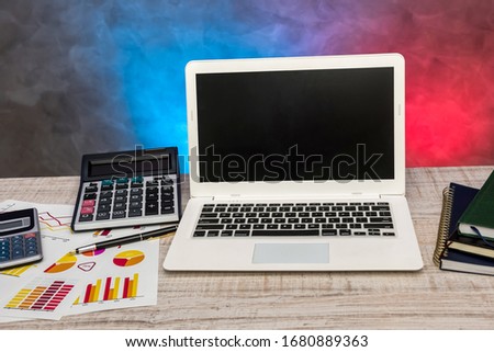 laptop and busines graph, calculator  on desk.