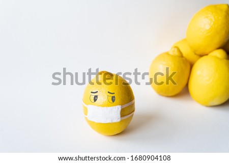 Lemon wearing medical mask isolated from the crowd. Conceptual image of social distancing.