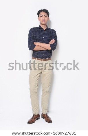 full length  portrait of young man in blue shirts with khaki pants with arms crossed on white background
 Royalty-Free Stock Photo #1680927631