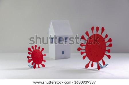 Representation of virus COVID 19 made from paper trying to enter quarantined houses