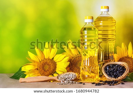 Rural still-life - sunflower oil in bottles with flowers of sunflower (Helianthus annuus), closeup Royalty-Free Stock Photo #1680944782