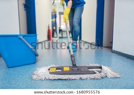 Close-up of cleaners moping the floor of a hall Royalty-Free Stock Photo #1680955576