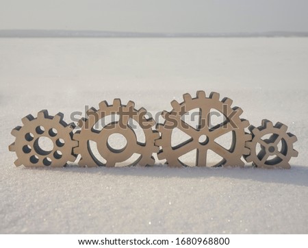 4 four wooden gear lie on snow background. idea of  winter studded wheels