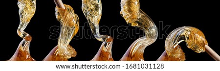 Viscous transparent yellow liquid flows close-up isolated on black background Royalty-Free Stock Photo #1681031128