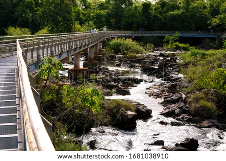 Bridge over the river to Devil's throat in Iguazu Falls, one of the seven natural wonders of the world. Misiones, Argentina. Royalty-Free Stock Photo #1681038910