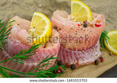 fish fillets of dogfish with lemon herbs on black background Royalty-Free Stock Photo #1681053703