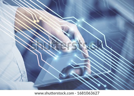 Double exposure of man's hand holding and using a digital device and data theme hologram drawing. Technology concept.
