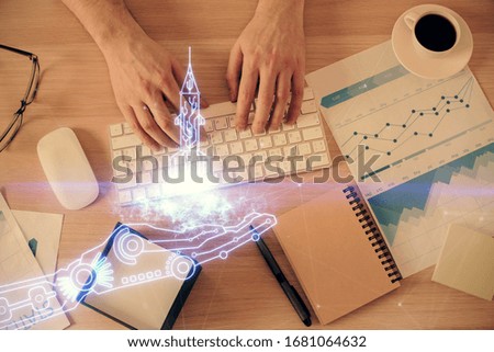 Double exposure of man's hands typing over computer keyboard and conceptual start up theme drawing. Top view.
