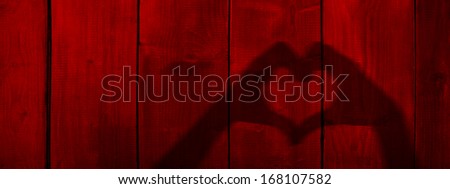 Concept or conceptual Valentine human man and woman hands silhouette as heart or love symbol on old red wood background,metaphor to romantic,romance,relationship,young,couple,emotions,wedding or lover