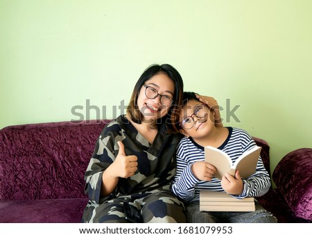 Homeschool, social distancing, Safety in the COVID19 period. Asian mother and son sitting and reading together in living room. Happiness moment, family relationship build a positive attitude. Thumb up