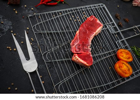 Top down view of red sirloin on a grilling rack with herbs surrounding