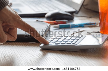 Hand of business man using calculator,soft focus.