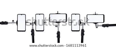 A lot of smartphones mounted on tripods and holders in different positions on a white isolated background.