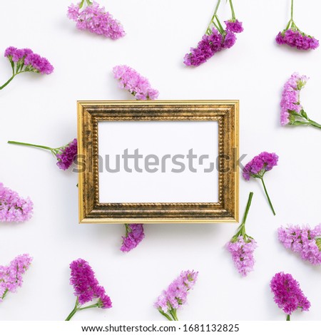 Antique picture frame with pink purple statice flowers on white background. Floral composition, flat lay, top view, copy space