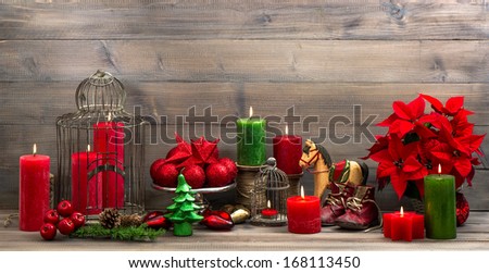 vintage christmas decorations with red candles, antique baby shoes, flower poinsettia, stars and baubles. retro style picture