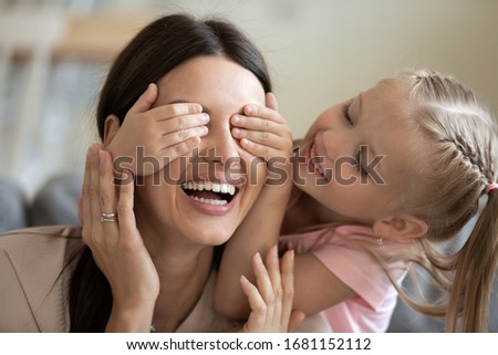 Close up of cute little girl close smiling mother eyes have fun involved in funny activity at home, overjoyed small preschooler daughter play with happy young mom enjoy playful weekend time together