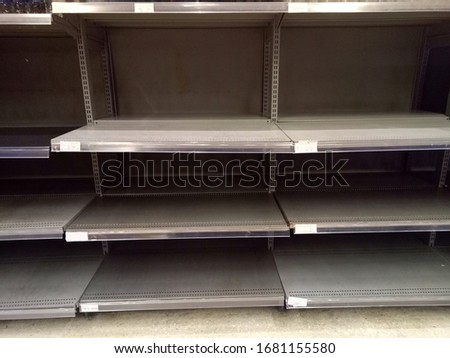 Emtpy shelves in supermarket due to panic shopping because of Corona-Virus, Covid-19. Business and healthcare concept.