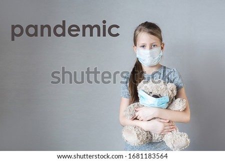 Concept of coronavirus , air pollution and quarantine compliance. Child girl in protective medicine mask and teddy bear toy. Medical masks for protection to stop a corona virus outbreak. copy space