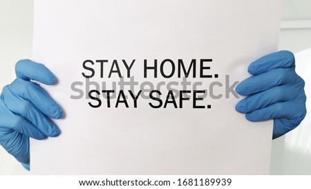 Coronavirus, COVID-19, self-quarantine, isolation, social disdancing  concept. Doctor's hands with blue protective nitride gloves holding Stay home, stay safe message. Royalty-Free Stock Photo #1681189939