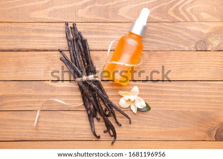 Aromatic vanilla extract on wooden background