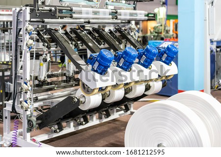 Raw material plastic roll set on feed set of high technology modern and automatic high speed continuous manufacturing process plastic bag sack or plastic envelope making machine for industrial  Royalty-Free Stock Photo #1681212595