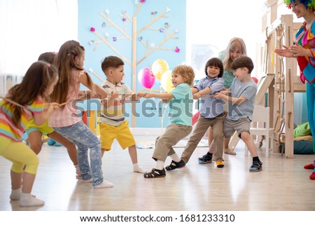 Group of children in a rope-pulling contest in kindergarten Royalty-Free Stock Photo #1681233310