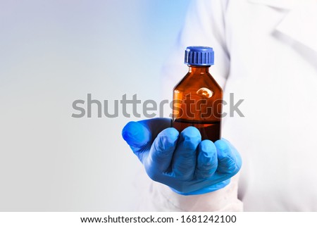 Doctor hand in sterile gloves holding glass vial isolated on white background 