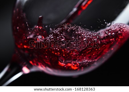  Red wine in wineglass on  black background Royalty-Free Stock Photo #168128363