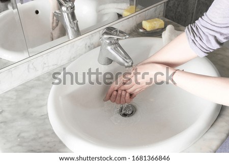 Woman washing hand in bathroom interior. Washing hands  for  prevention against any virus concept.