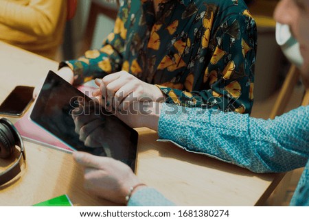 Couple man and woman hand using tablet together on wooden table. Young couple doing coworking in the office. Job and relationship concept - Image
