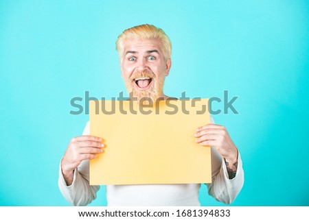 Man with blank sheet paper. Copy space for advertising. Colorful studio portrait on isolated background. Portrait of man holding sign card