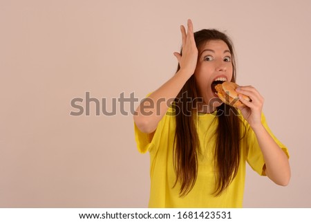 hungry woman eating a burger on a light background