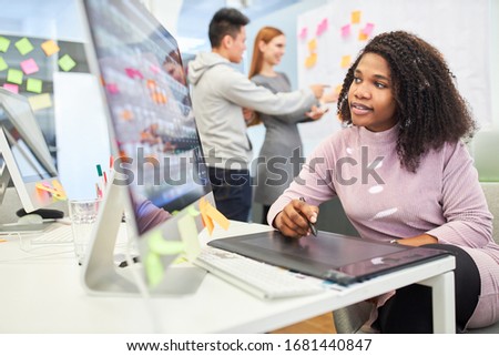 African woman as graphic designer on tablet computer in internet agency office