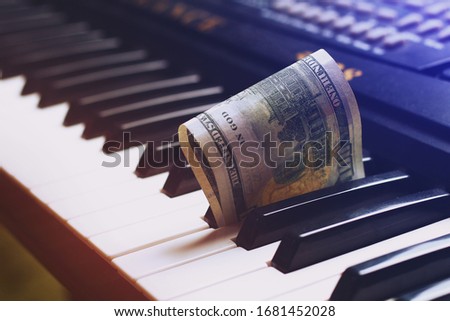 Dollars on the keys of the piano, background, toned