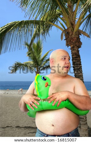 A large man with inflatable toy gets ready to go into the ocean.