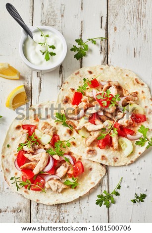 Grilled chicken and fresh  vegetables salad  tortilla .Healthy delicious breakfast or snack , top view. Flat lay.Outdoors Food Concept