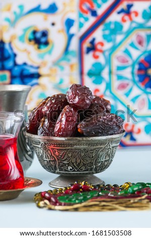 Medjoul kurma in a vintage bowl and glass of turkish tea. Close up.
