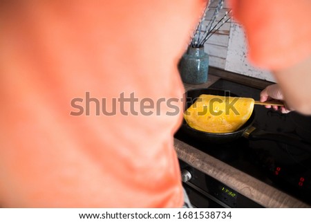 A man flips an omelet in a pan