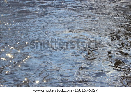 Water surface with waves and glare of light. Place for text and design.