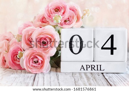 White wood calendar blocks with the date April 4th. Selective focus with blurred background. Easter 2021