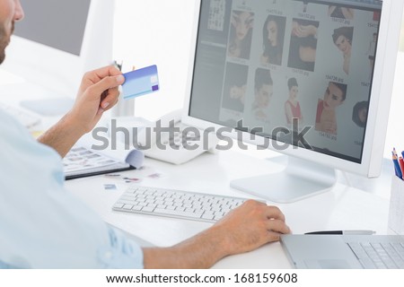 Side view of a male photo editor working on computer in a bright office